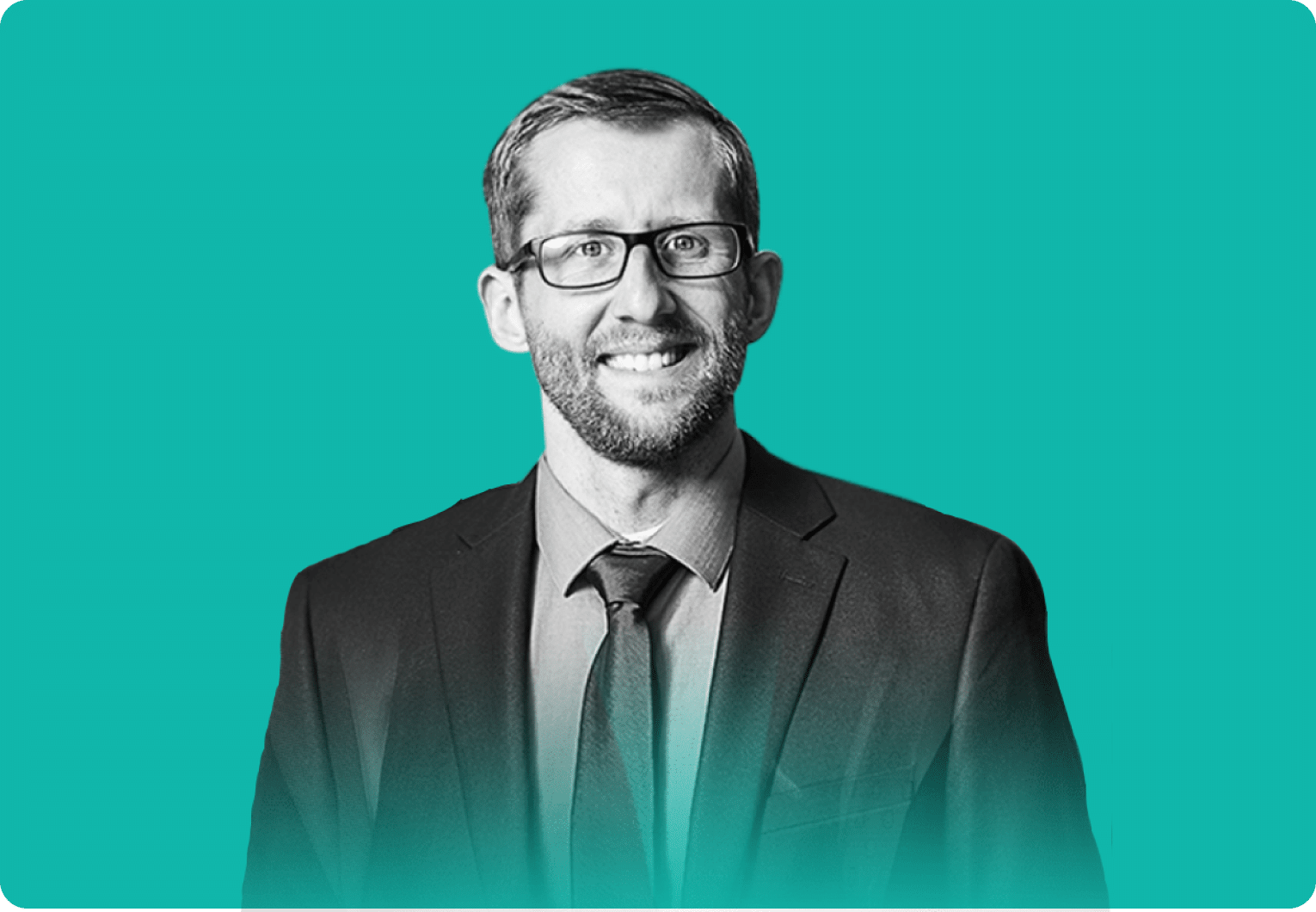 Smiling man in glasses wearing a suit and tie against a teal background (professional headshot)